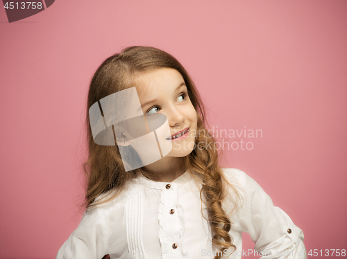 Image of The happy teen girl standing and smiling against pink background.