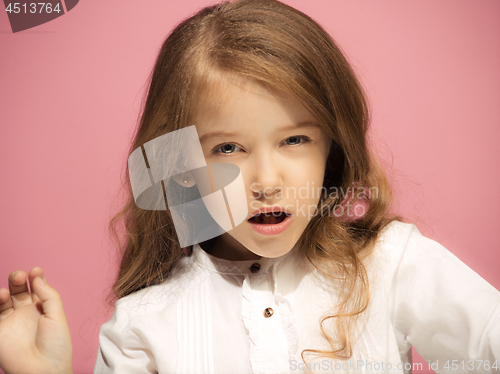 Image of Portrait of angry teen girl on a pink studio background