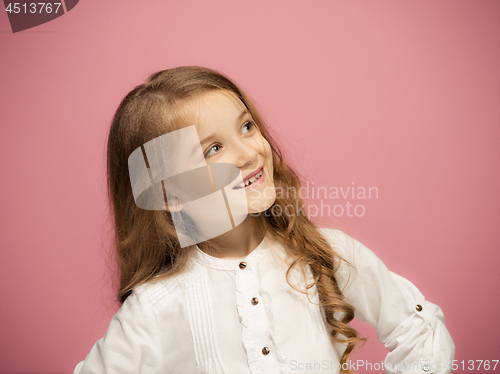 Image of The happy teen girl standing and smiling against pink background.