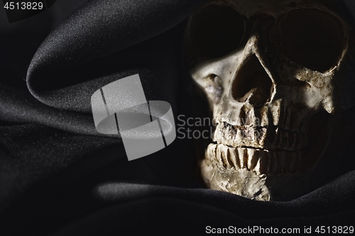 Image of Closeup photo an old skull covered in black robe