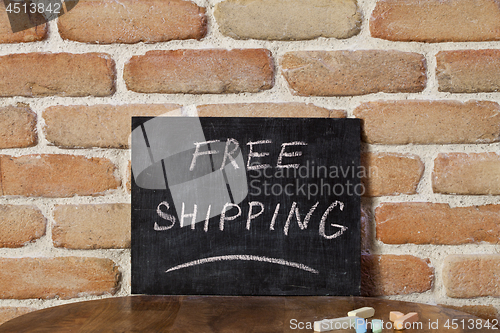 Image of Black chalkboard with the phrase FREE SHIPPING drown by hand on 