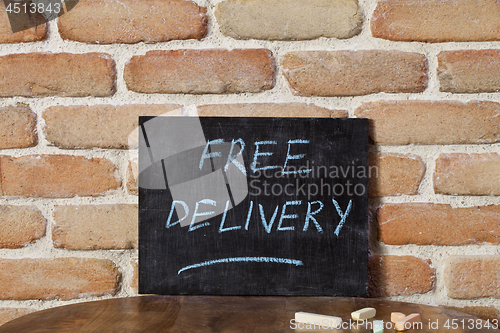 Image of Black chalkboard with the phrase FREE DELIVERY drown by hand on 