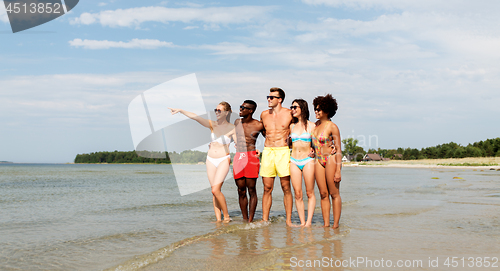 Image of happy friends hugging on summer beach