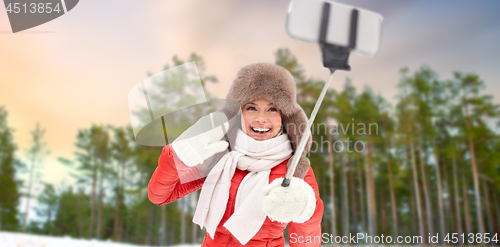 Image of happy woman taking selfie over winter forest