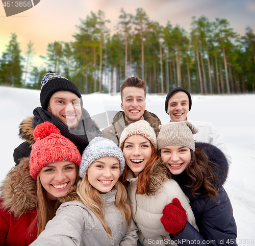 Image of group of friends taking selfie outdoors in winter