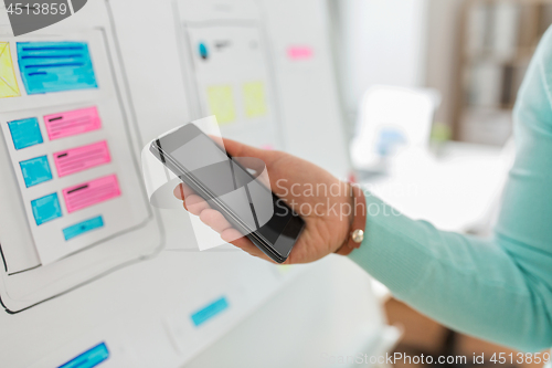 Image of ui designer or developer hand holding smartphone
