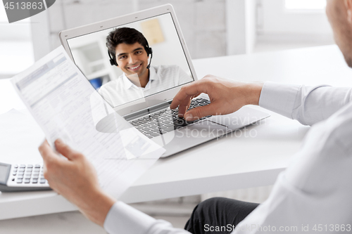 Image of businessman having video call on laptop at office