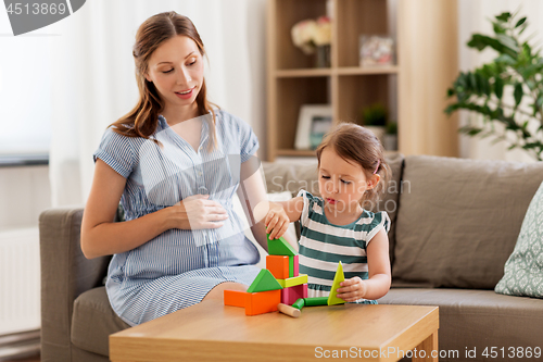 Image of pregnant mother and daughter with toy blocks