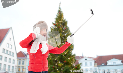 Image of woman taking selfie over christmas tree