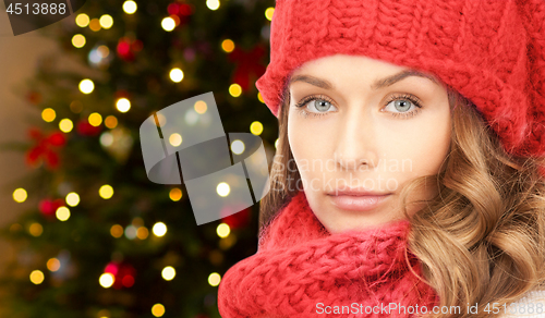 Image of woman in hat and scarf over christmas lights