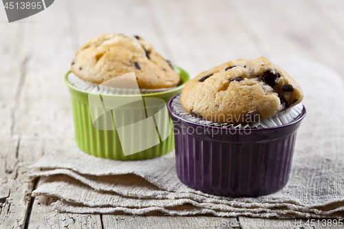 Image of Homemade fresh muffins on ceramic bowls on linen napkin.