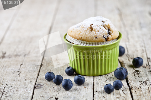 Image of Homemade fresh muffin on ceramic green bowl with blueberries on 