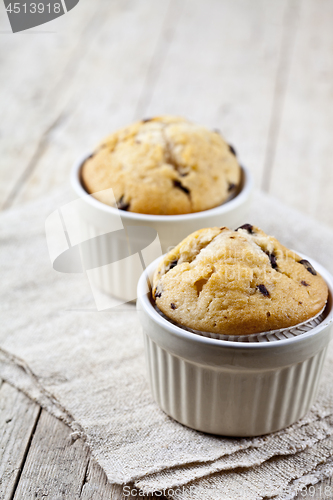 Image of Two homemade fresh muffins on ceramic white bowls on linen napki