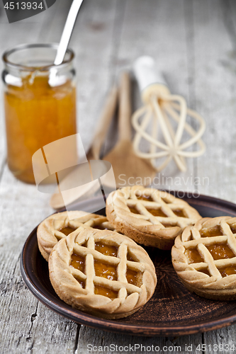 Image of Fresh baked tarts with marmalade or apricot jam filling and on c