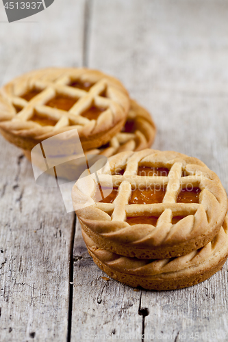 Image of Fresh baked tarts with marmalade or apricot jam filling on on ru