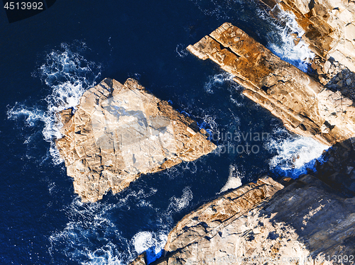 Image of Shapely exposed rock slabs in deep water off the coast