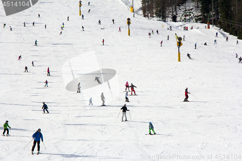 Image of Lots of skiers and snowboarders on the slope at ski resort 