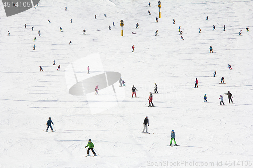 Image of Lots of skiers and snowboarders on the slope at ski resort 