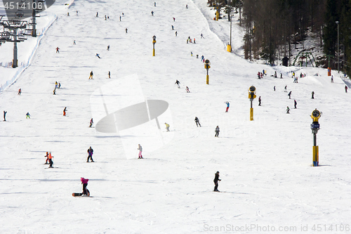 Image of Lots of skiers and snowboarders on the slope at ski resort 