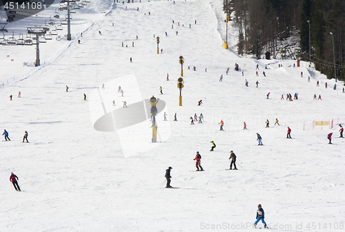 Image of Lots of skiers and snowboarders on the slope at ski resort 