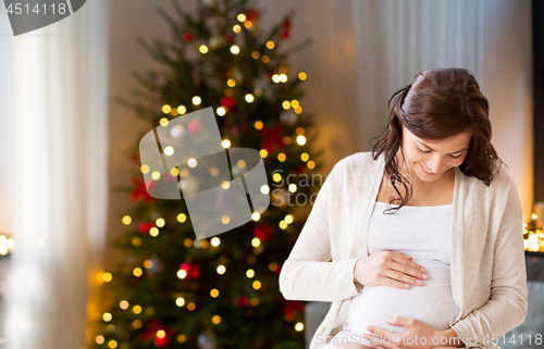 Image of happy pregnant woman at home on christmas