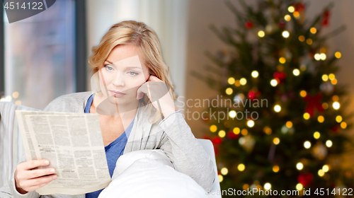 Image of woman reading newspaper on christmas at home