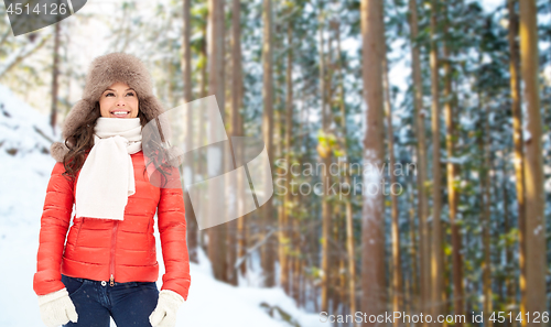 Image of happy woman in fur hat over winter forest