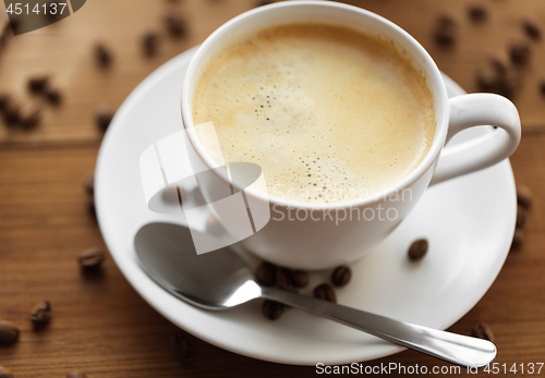 Image of close up coffee cup and beans on wooden table