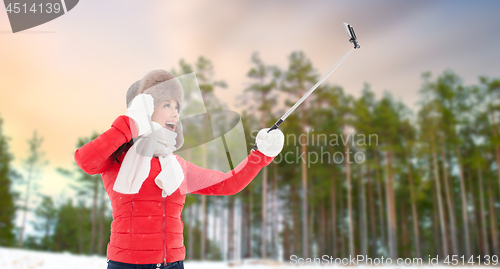 Image of happy woman taking selfie over winter forest
