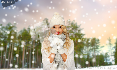 Image of happy woman in hat and scarf over winter forest