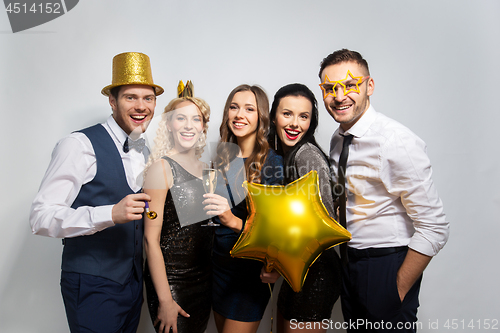 Image of happy friends with golden party props posing