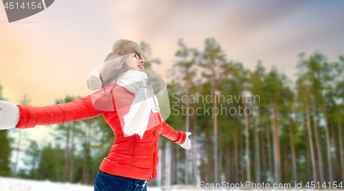 Image of happy woman in fur hat over winter forest