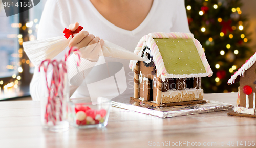 Image of woman making gingerbread houses on christmas