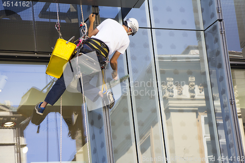 Image of Window washer cleaning the windows of shopping center