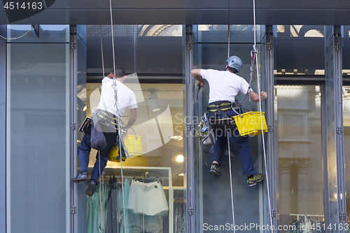 Image of Window washers cleaning the windows of shopping center