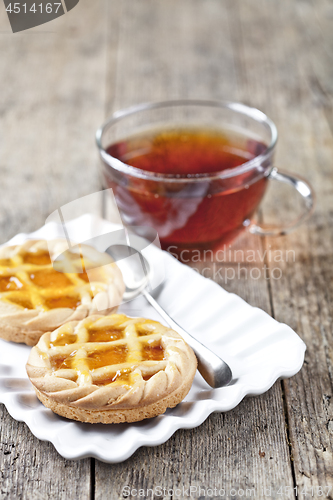 Image of Fresh baked tarts with marmalade or apricot jam filling on white