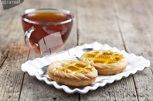 Image of Fresh baked tarts with marmalade or apricot jam filling on white
