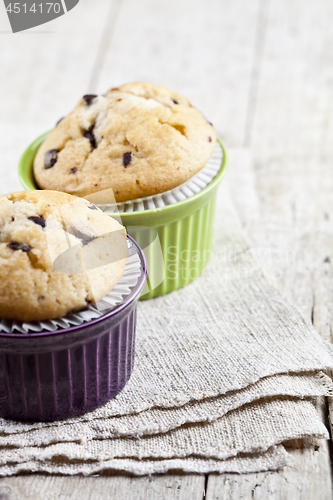 Image of Homemade fresh muffins on ceramic bowls on linen napkin on rusti