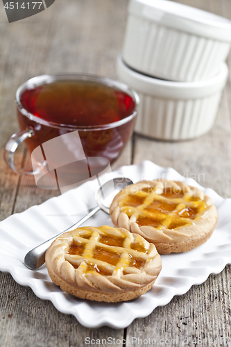 Image of Fresh baked tarts with marmalade or apricot jam filling on white