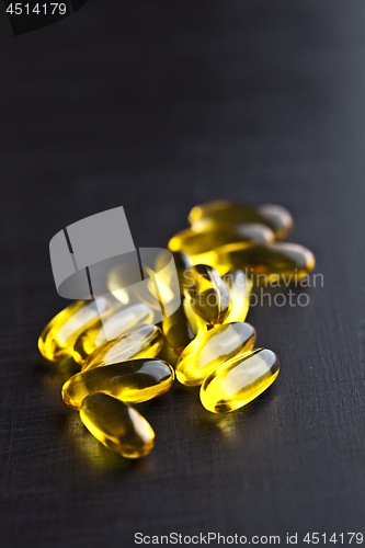 Image of Omega-3 oil capsules and vitamin for health care on black board 