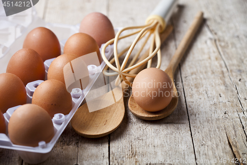 Image of Fresh chicken eggs on plastic container and kitchen utensil on r