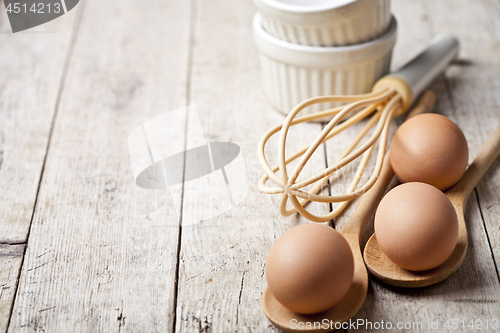 Image of Fresh chicken eggs and kitchen utensil on rustic wooden table ba