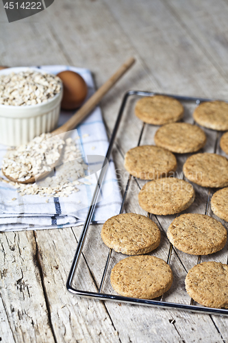 Image of Baking grid with fresh oat cookies on rustic wooden table backgr
