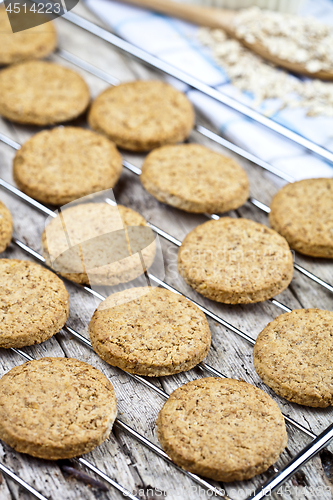 Image of Baking grid with fresh oat cookies on rustic wooden table backgr