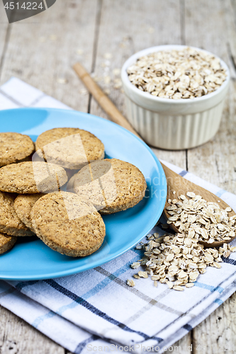 Image of Fresh baked oat cookies on blue ceramic plate on linen napkin an