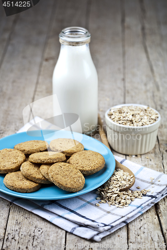 Image of Fresh baked oat cookies on blue ceramic plate on linen napkin, b