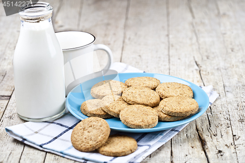 Image of Fresh baked oat cookies on blue ceramic plate on linen napkin, b