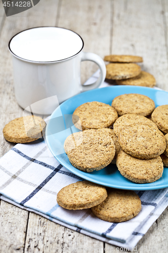 Image of Fresh baked oat cookies on blue ceramic plate on linen napkin an