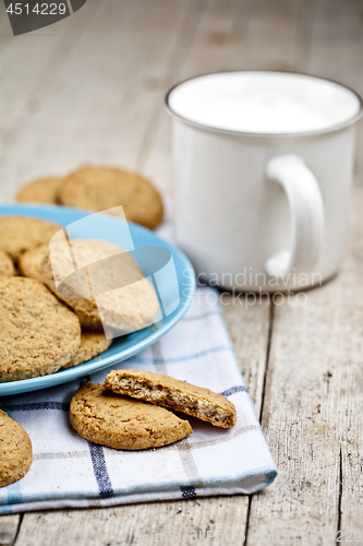 Image of Fresh baked oat cookies on blue ceramic plate on linen napkin an