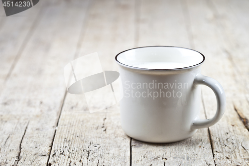 Image of Fresh milk on white ceramic cup on rustic wooden table backgroun